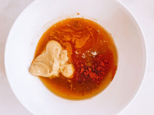 Honey mustard dressing ingredient in a mixing bowl, unmixed.