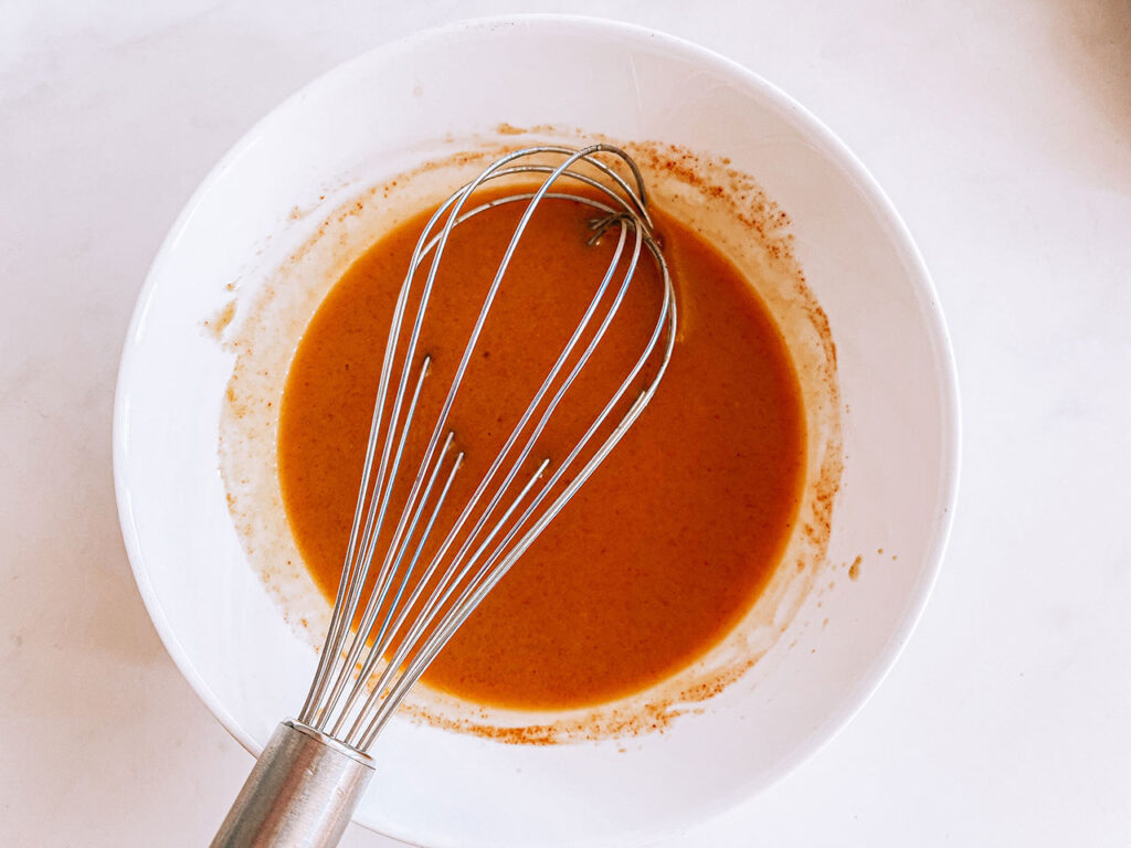 Honey mustard dressing ingredients whisked together.