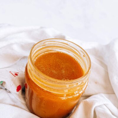 Top angled view of an open jar of honey mustard dressing.