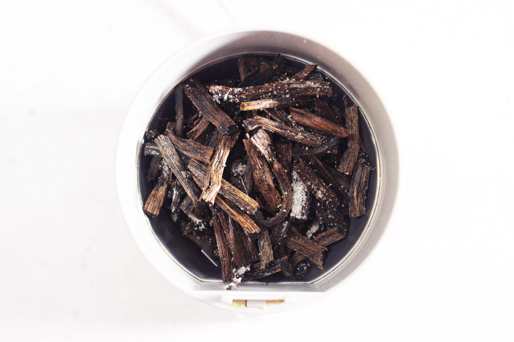 Small pieces of dried vanilla bean in a spice grinder.