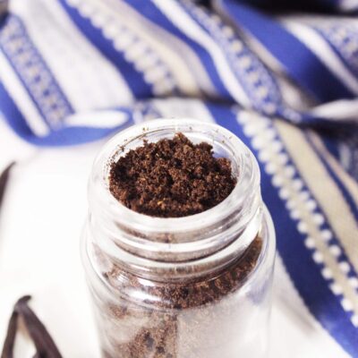 Slightly overhead view of a glass spice jar filled with vanilla powder.
