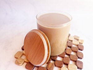 Front view of a glass cup of Coffee Smoothie with a cup lid leaning against the cup.