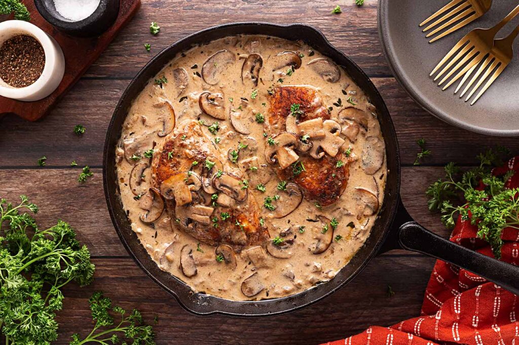 Overhead focus. Cast iron skillet filled with Creamy Mushroom Chicken.
