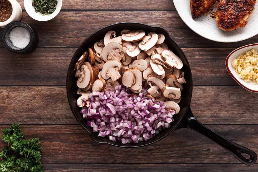 Mushrooms and onions in a cast iron skillet.