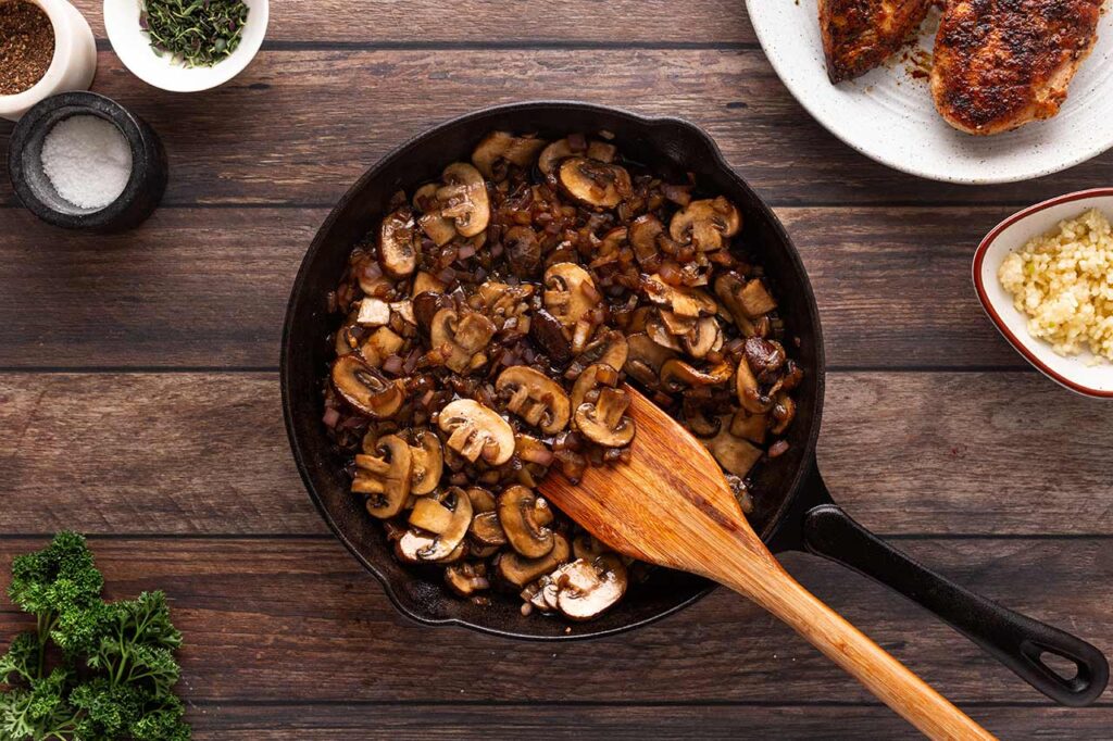 Cooked mushrooms and onions in a cast iron skillet. Overhead focus.