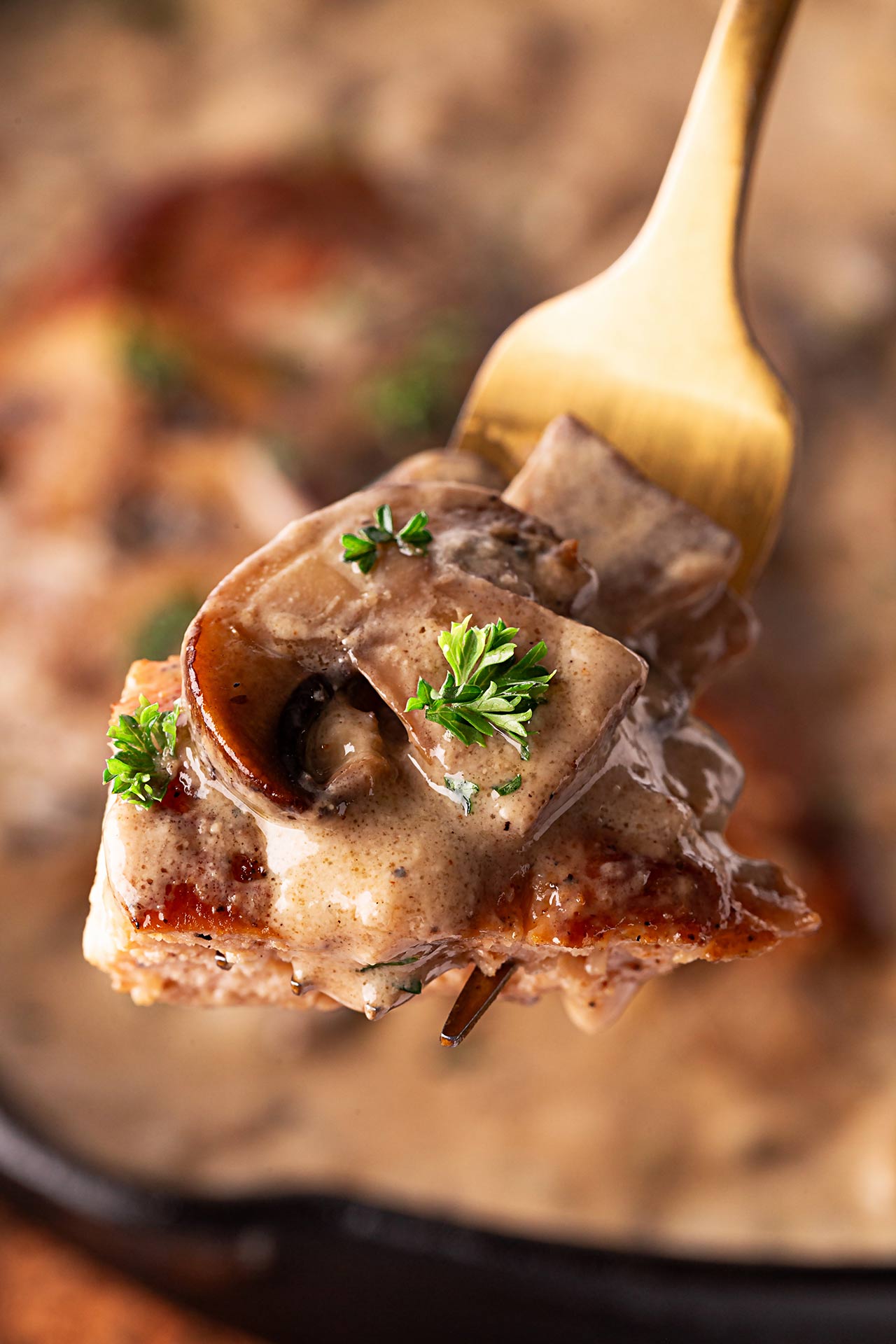 Closeup of a fork holding a bite of Creamy Mushroom Chicken.