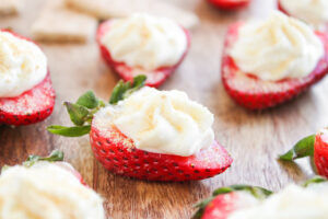 Front view closeup of Deviled Strawberries on a wood cutting board.