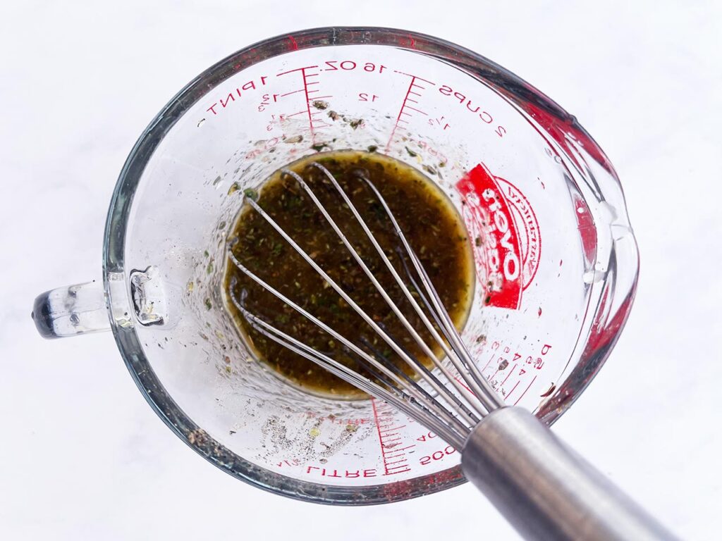 Dressing mixed in a measuring cup.