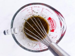 Dressing mixed in a measuring cup.