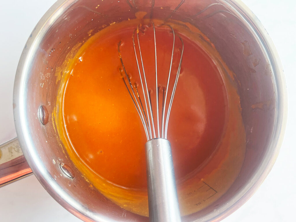 Finished Bravas sauce in a pot with a whisk. Overhead focus.