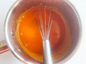 Finished Bravas sauce in a pot with a whisk. Overhead focus.