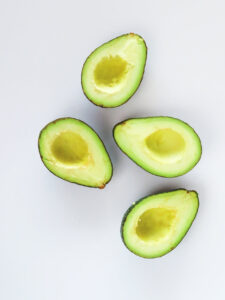 Cut avocados on a white surface.