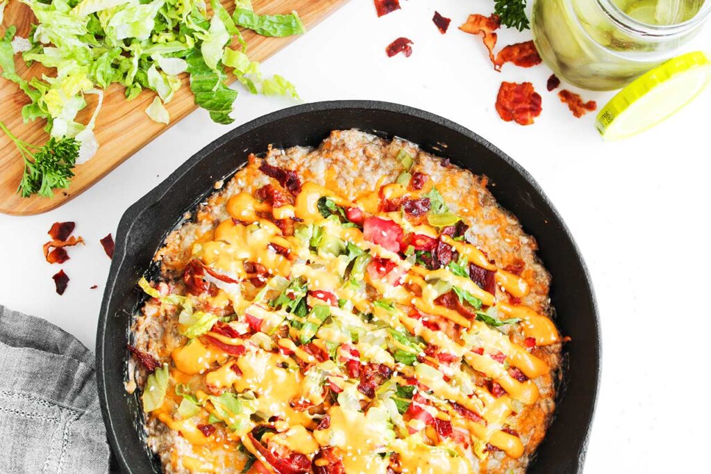 Partial overhead focus. A cast iron skillet filled with cheeseburger dip.