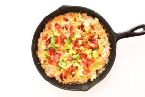 Lettuce, tomatoes, a chopped bacon added as toppings to cheese burger dip.