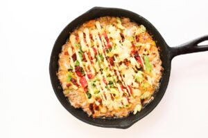Sauce drizzled over the to of cheese burger dip.