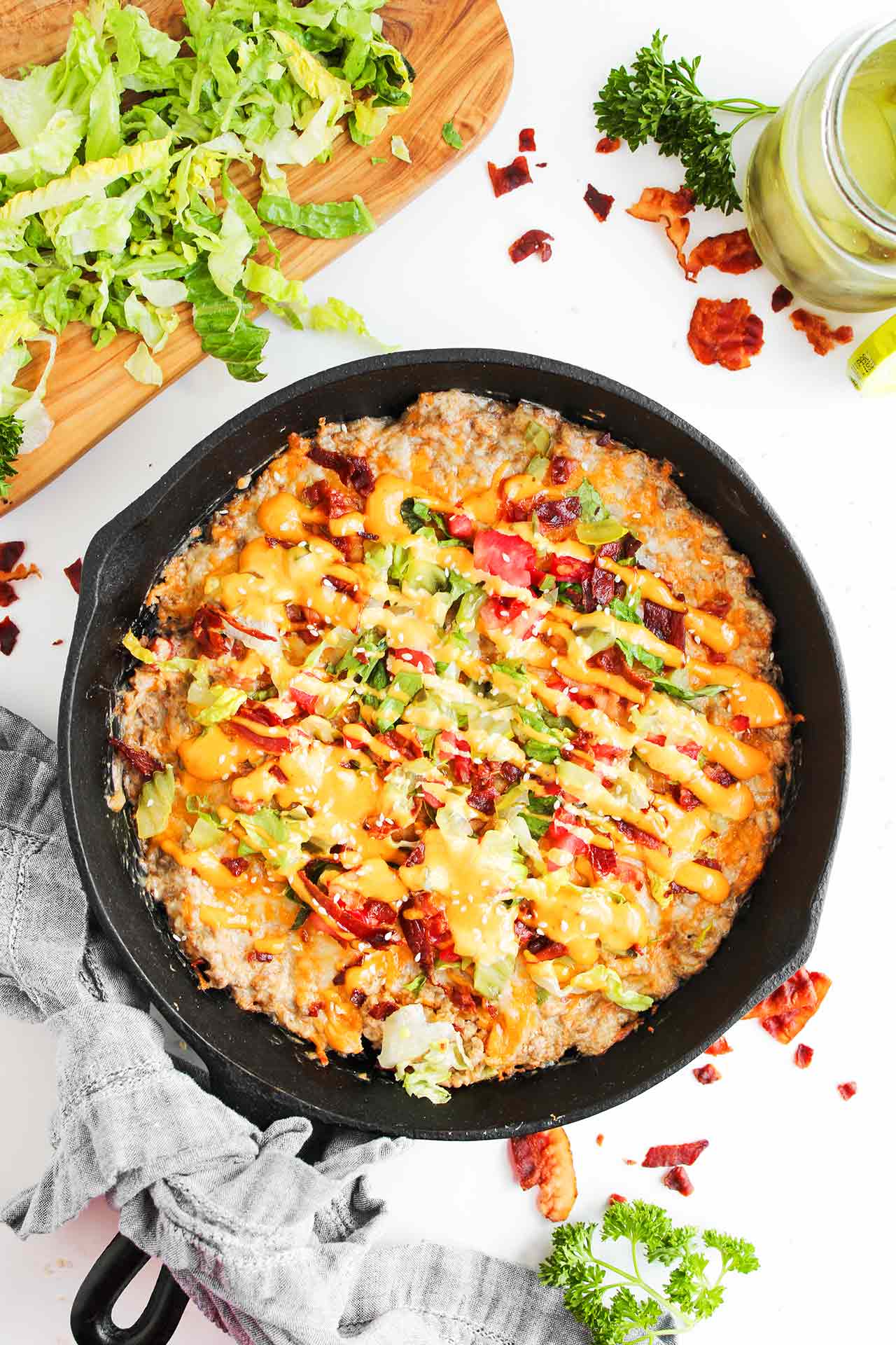 Overhead focus. A cast iron skillet filled with cheeseburger dip.