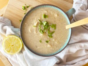 Closeup, overhead focus. A mug filled with Greek Avgolemono Soup.