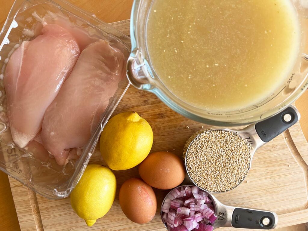 Greek Avgolemono Soup ingredients gathered on a wood surface.