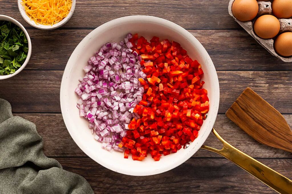 Chopped peppers and onion in a skillet.
