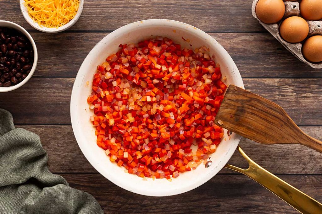 Cooked onions and peppers in a skillet.