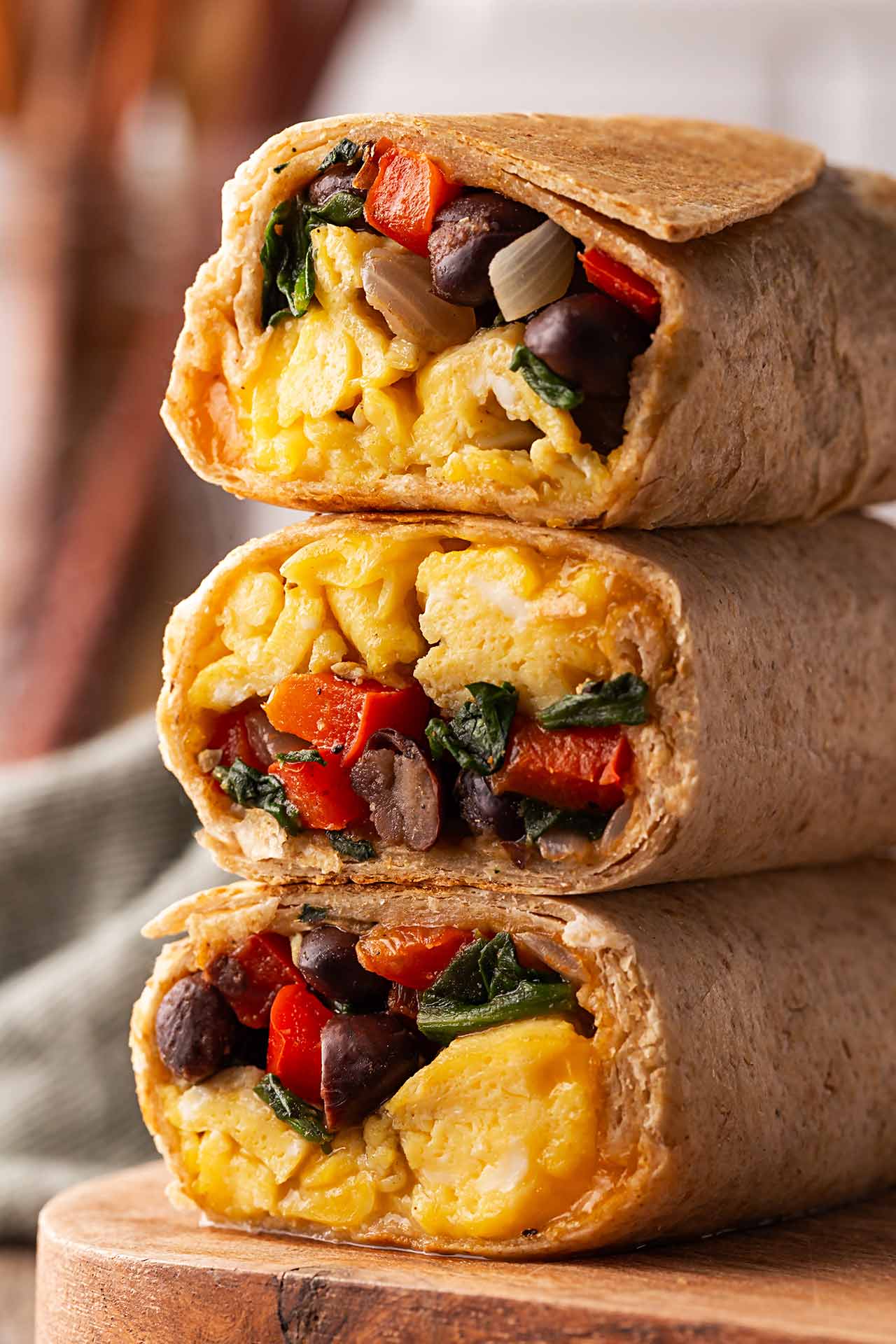 A stack of three cut Healthy Breakfast Burritos in a tall stack.