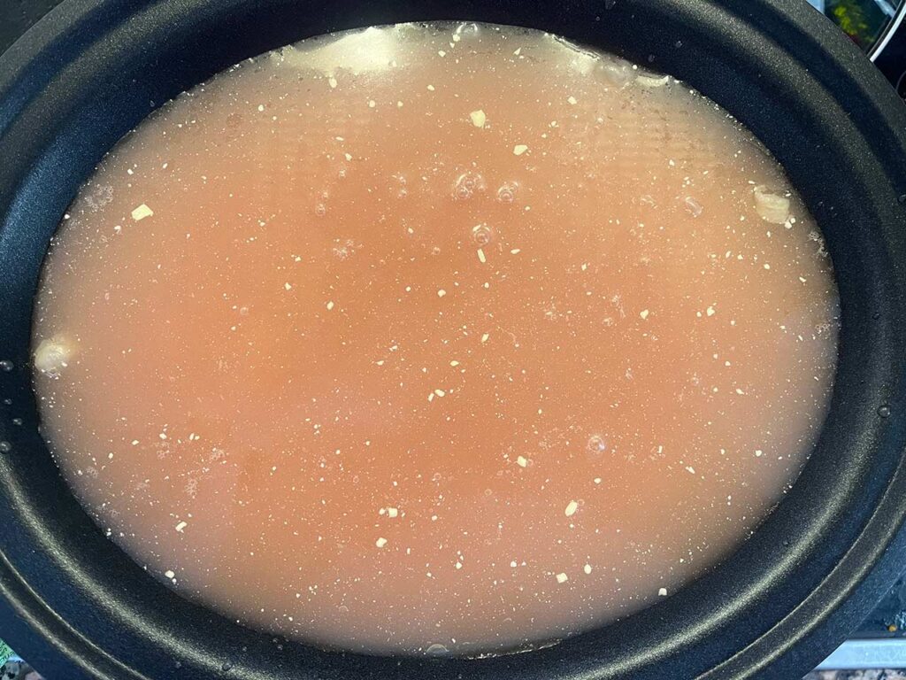 Broth added to a slow cooker crock.