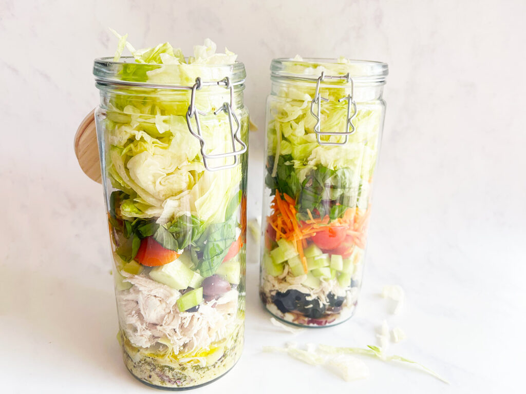 Two Mediterranean Detox Salad Jars on a white background.