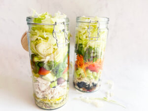 Two Mediterranean Detox Salad Jars on a white background.
