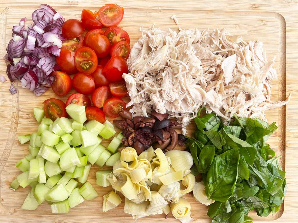 Mediterranean Detox Salad Jar ingredients cut and laying on a cutting board.