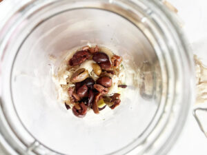 Chicken and olives added to a salad jar.