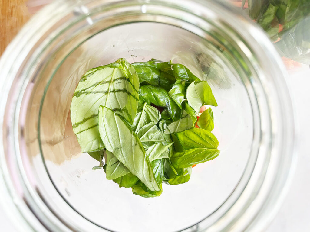 Fresh basil added to a salad jar.