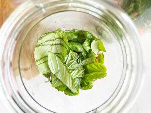 Fresh basil added to a salad jar.
