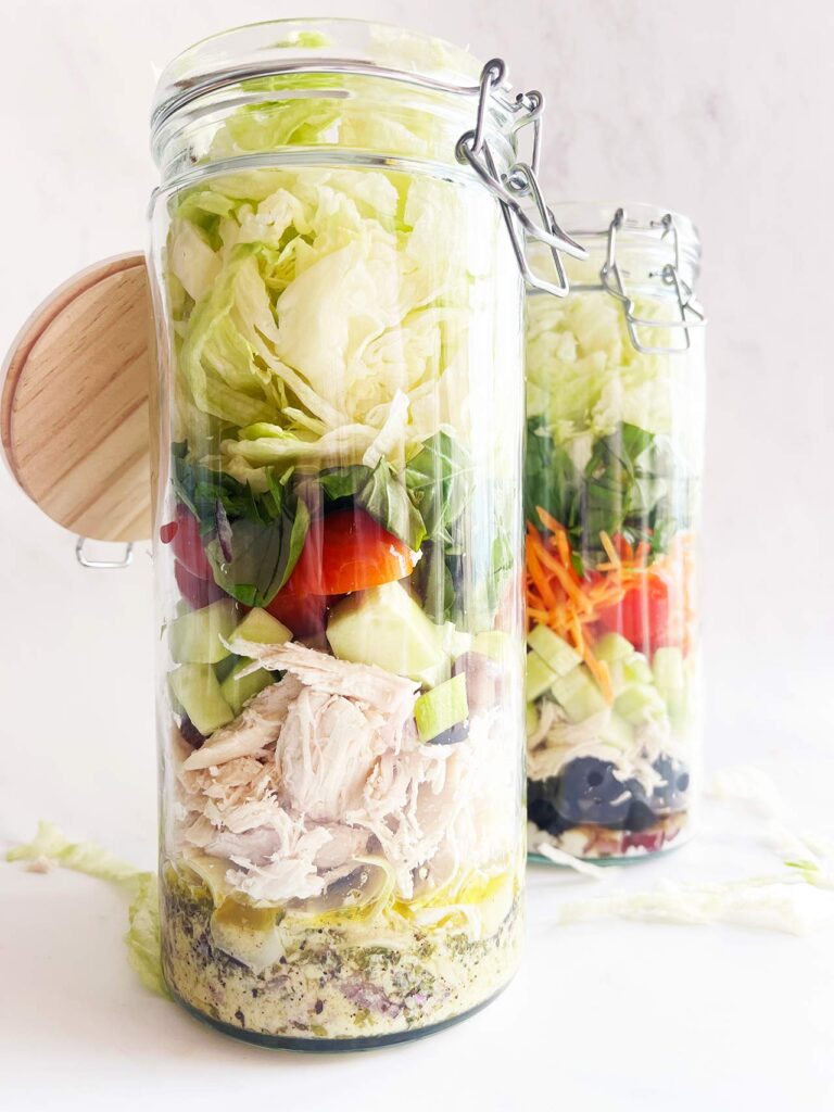 From the bottom looking up at two Mediterranean Detox Salad Jars on a white background.