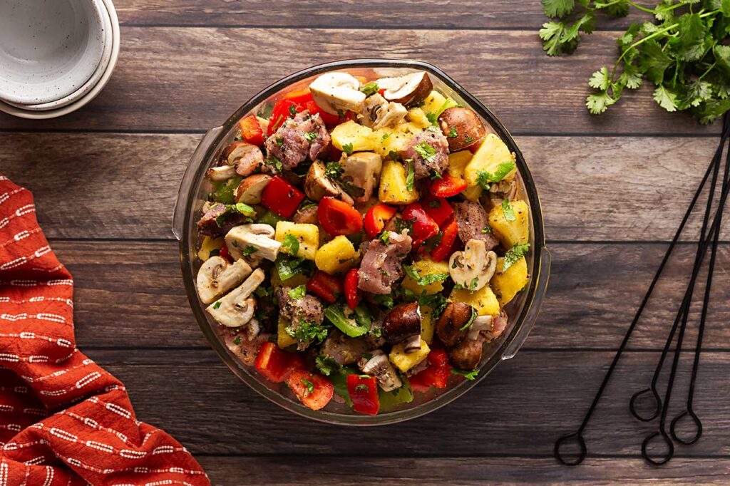 Mixed Pork Kabob ingredients in a glass mixing bowl.
