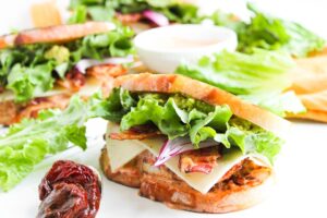 Several Chipotle Chicken Club Sandwiches on a white surface.