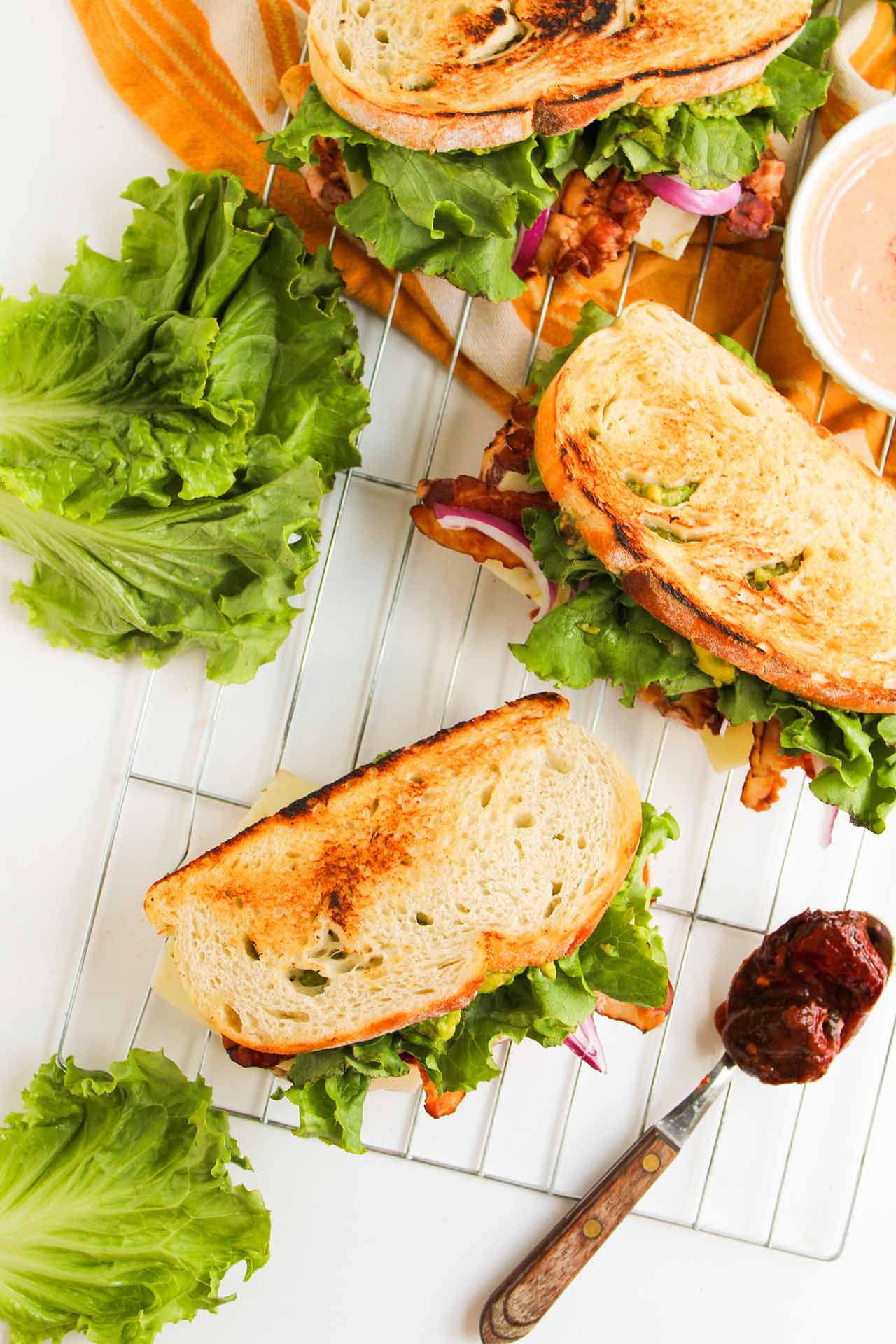 Chipotle Chicken Club Sandwiches arranged on a wire rack. Overhead view.