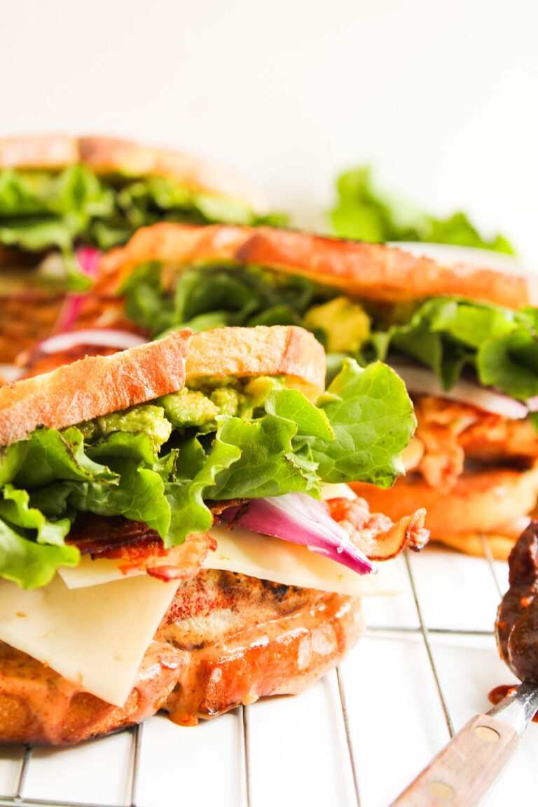 Closeup front view of a Chipotle Chicken Club Sandwich on a wire rack.