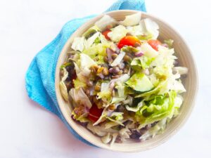 Closeup overhead view of a bowl of Fusion Lentil Salad on a white background.