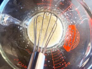 Mixed dressing in a measuring cup. Overhead focus.
