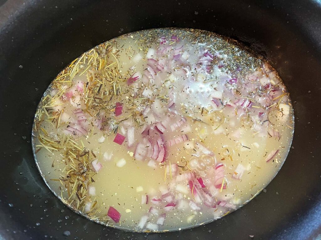 Broth added to a slow cooker crock.