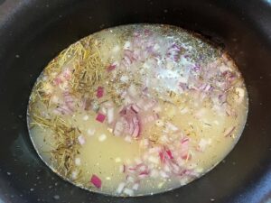 Broth added to a slow cooker crock.