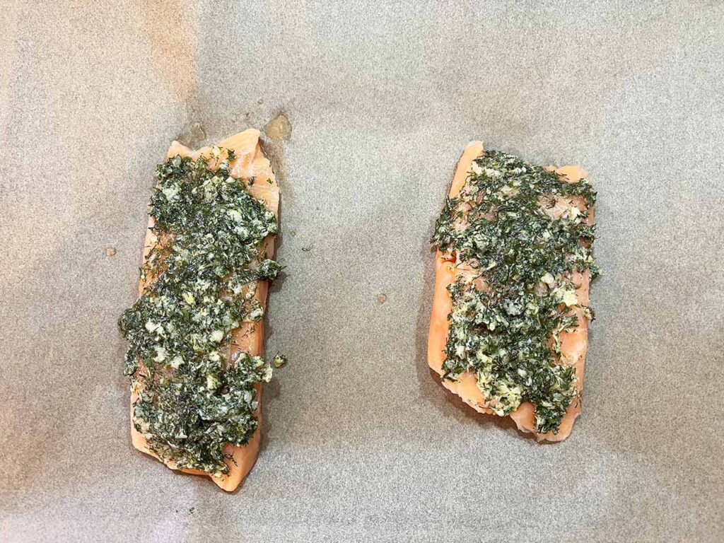 Two salmon fillets smothered in herbs, garlic and olive oil.