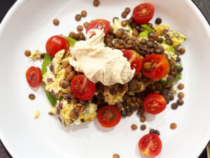 A Mediterranean Omelette topped with cut cherry tomatoes and a dollop of hummus.
