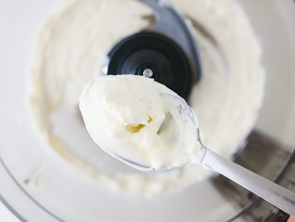Whipped feta on a spoon scraped from a food processor.