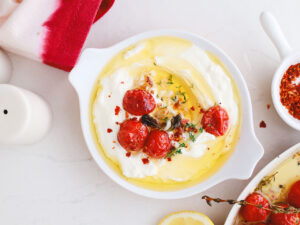 Overhead view of whipped feta in a serving dish with tomato confit on top.