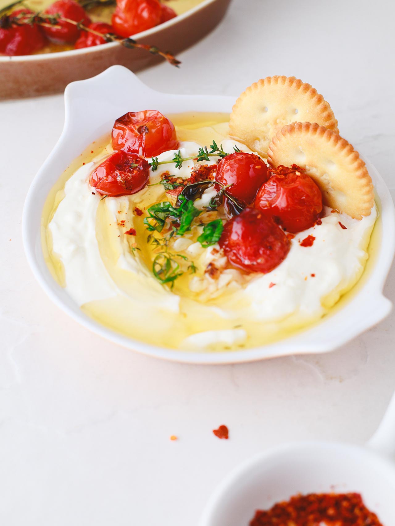 Front view of a white dish filled with Whipped Feta Dip.