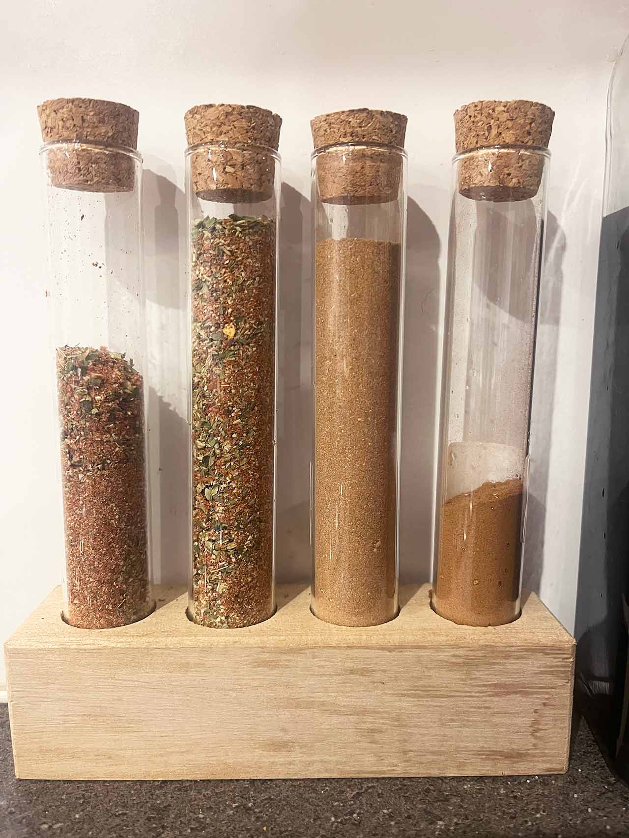A row of homemade spice blends in glass tubes.