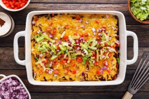 Overhead focus. A white casserole dish filled with Chicken Enchiladas.
