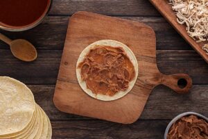 Beans spread over a corn tortilla.