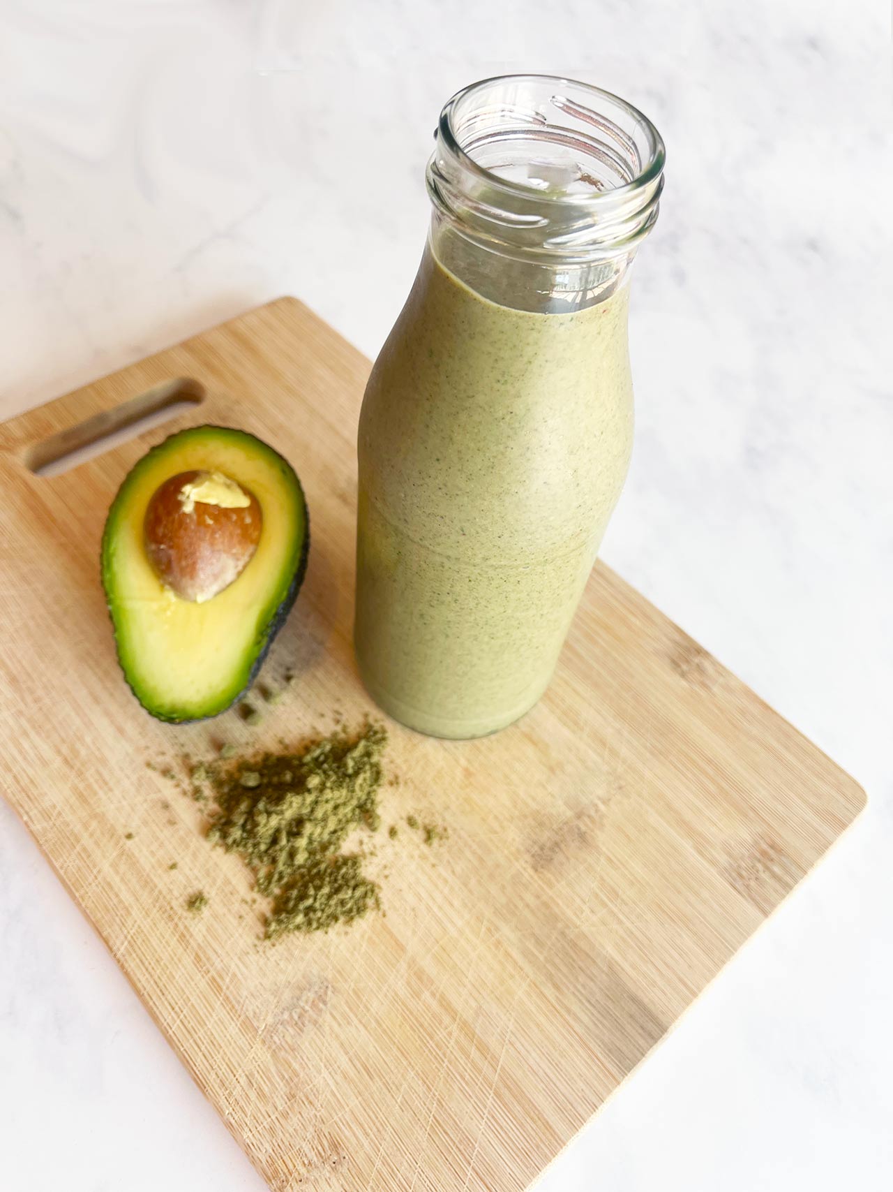 Angled front view of a jar of Hemp Protein Smoothie on a wood cutting board.
